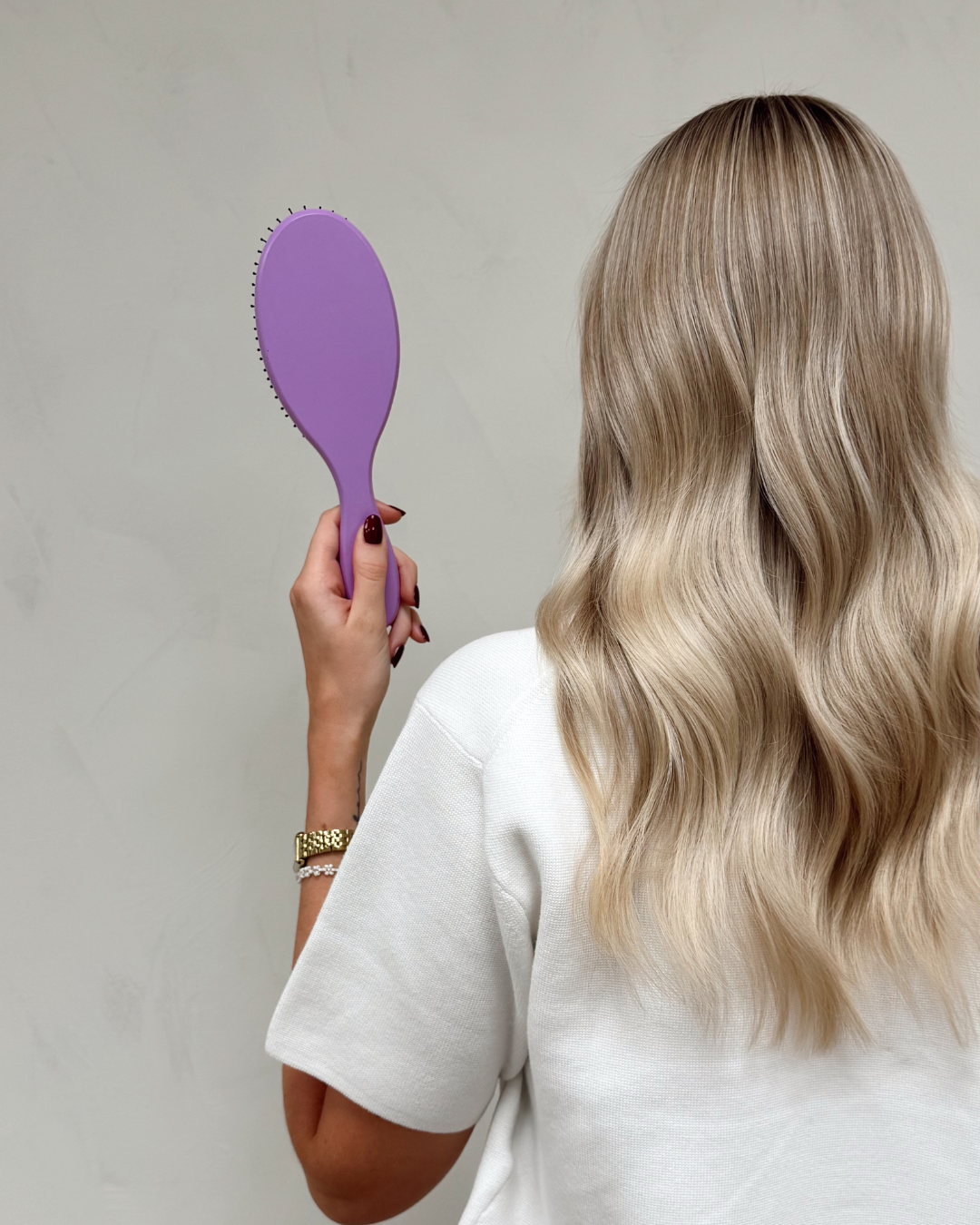 Molimenti Your Hair Brush i Lavender – limited edition hårborste i handen på kvinna med långt blont hår, redo för styling.
