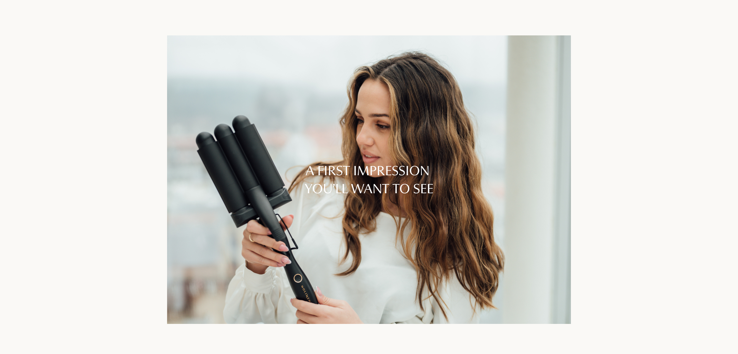 Vågtång från Molimenti. Modell håller i Your Wave Wand från Molimenti med texten “A first impression you’ll want to see” över bilden. Stylingverktyget visas i handen i en elegant miljö och signalerar premiumnivå och professionell prestanda.