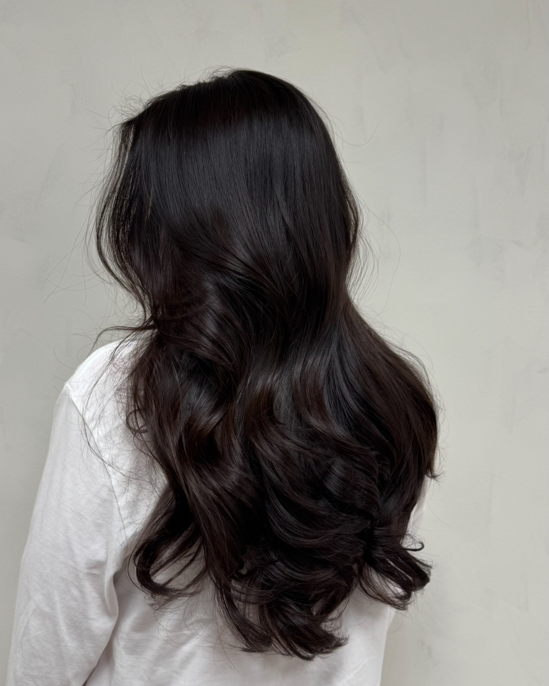 Mörkt, glansigt hår stylat i mjuka vågor med Your Curl Wand och Your Hair Brush från Molimenti Hair.