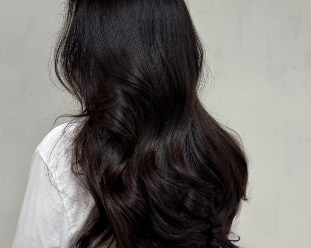 Mörkt, glansigt hår stylat i mjuka vågor med Your Curl Wand och Your Hair Brush från Molimenti Hair.