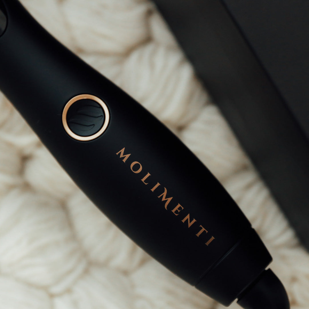 Your Wave Wand - Inzoomad bild på Molimentis logotyp graverad på värmeverktyget. Detaljbilden framhäver den eleganta designen och premiumkänslan i stylingverktygets finish.